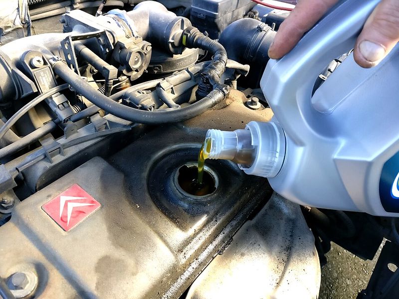 Engine oil being poured into a car engine